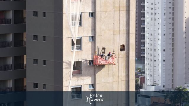 Obra em andaime suspenso em prédio alto