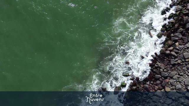 Ondas quebrando sobre pedras à beira-mar