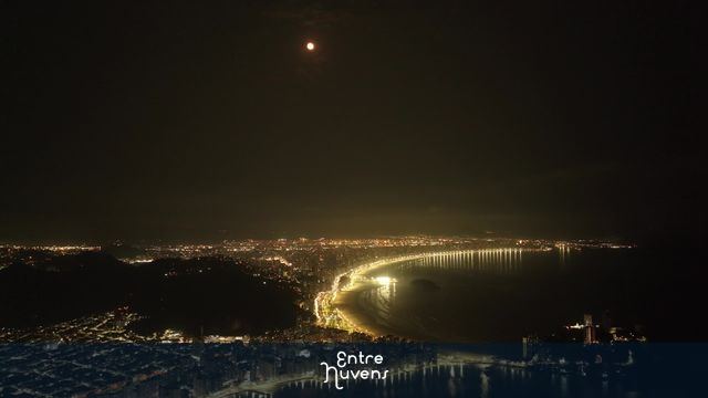 Orla Baixada Santista iluminada à noite sob a lua cheia