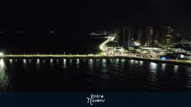 Orla da Península iluminada à noite com reflexos no mar