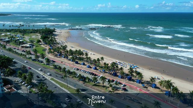 Orla movimentada e mar azul em dia ensolarado em Piatã