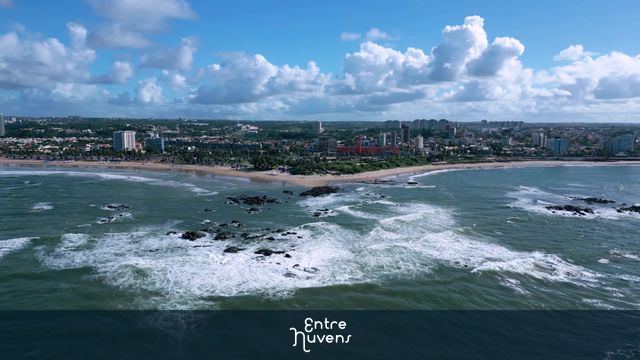 Orla Urbana com Ondas e Rochas na Praia