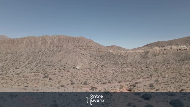Paisagem árida de montanhas avermelhadas e deserto