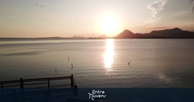 Pessoas no Deck de Araçatiba na Lagoa de Maricá durante o pôr do sol.