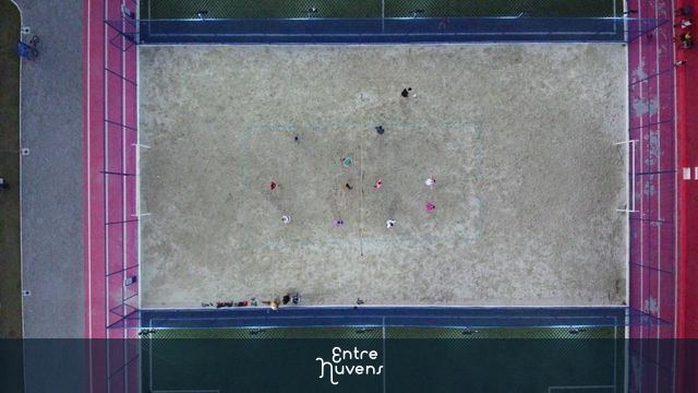 Pessoas praticando esporte na quadra de vôlei e futebol onde tem a escola de futebol do Zico — vídeo aéreo de Magé