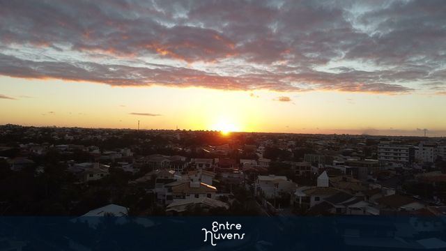 Pôr do Sol Dourado Ilumina a Paisagem Urbana com Nuvens Alaranjadas — vídeo aéreo de Lauro de Freitas