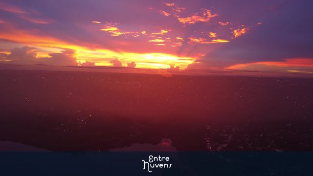 Por do sol radiante sobre rio e cidade