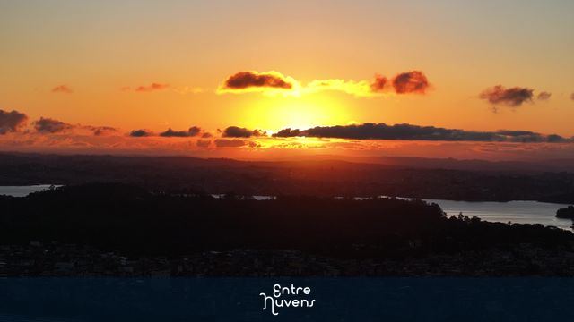 Pôr do sol sobre a cidade e a represa nuvens