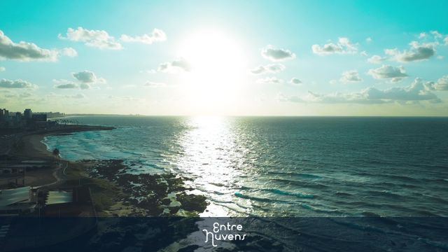 Pôr do sol sobre o mar e a orla urbana