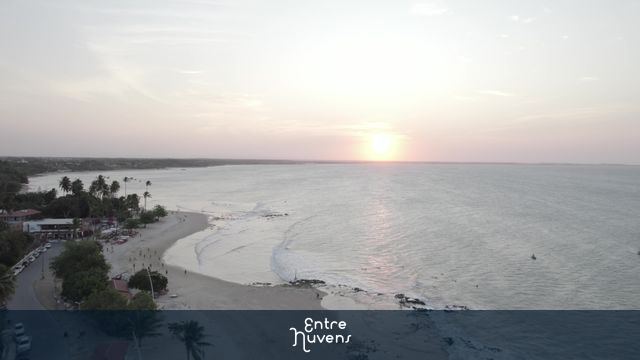 Pôr do sol sobre praia tranquila e mar aberto