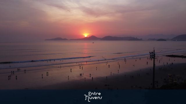 Pôr do sol vibrante na praia movimentada em santos, sao paulo
