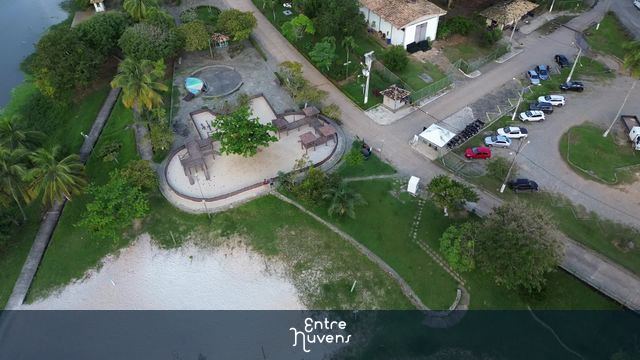 Praça arborizada com playground à beira-lago