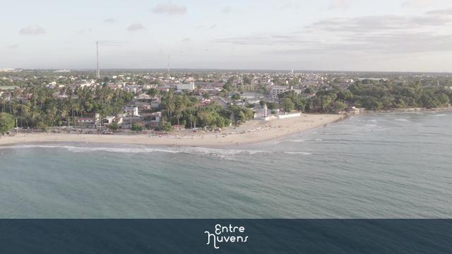 Praia central com mar calmo e orla urbana