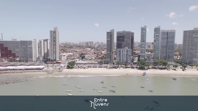 Praia urbana com barcos e arranha-céus