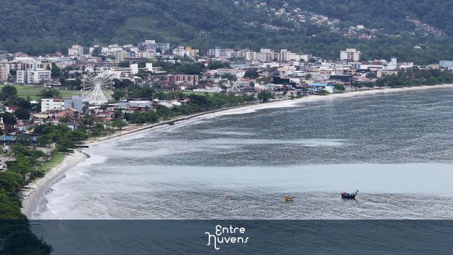 Praia urbana com roda gigante à beira-mar