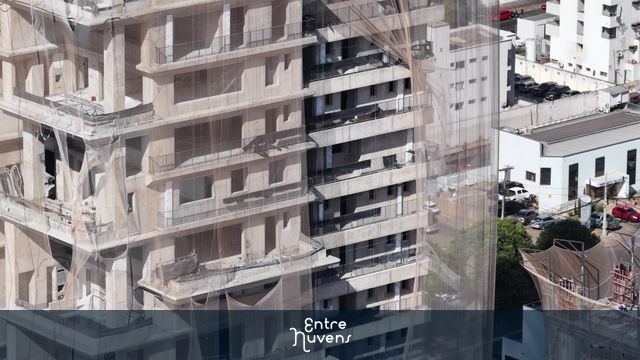 Prédio em construção coberto por telas