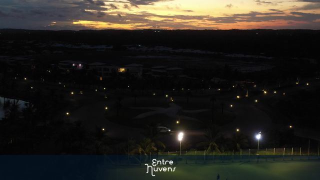 Rua, campo e lago iluminados ao entardecer — vídeo aéreo de Mata de São João