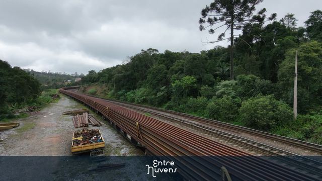 Transporte de Trilhos: Trem de Carga na Serra em Dia Nublado