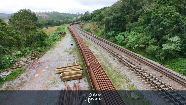 Trem de carga atravessando ferrovia em paisagem rural