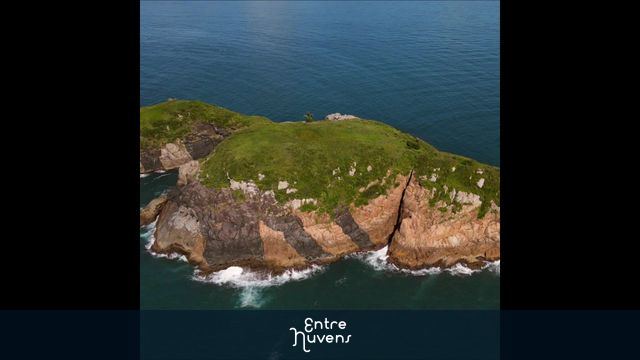 Video de uma pequena ilha perto do litoral de Santa Catarina. Mar calmo e céu azul, de longe se avista a praia dos Ingleses