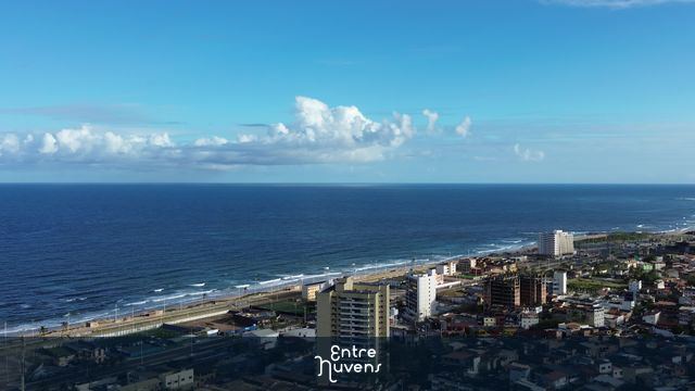 Vista aérea da orla com edifícios e mar azul