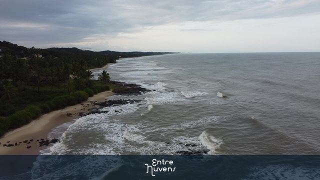 Voo em praia com pedras, surfistas ao fundo — vídeo aéreo de Ilhéus